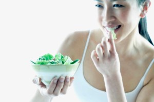 Young woman eating salad --- Image by © Royalty-Free/Corbis